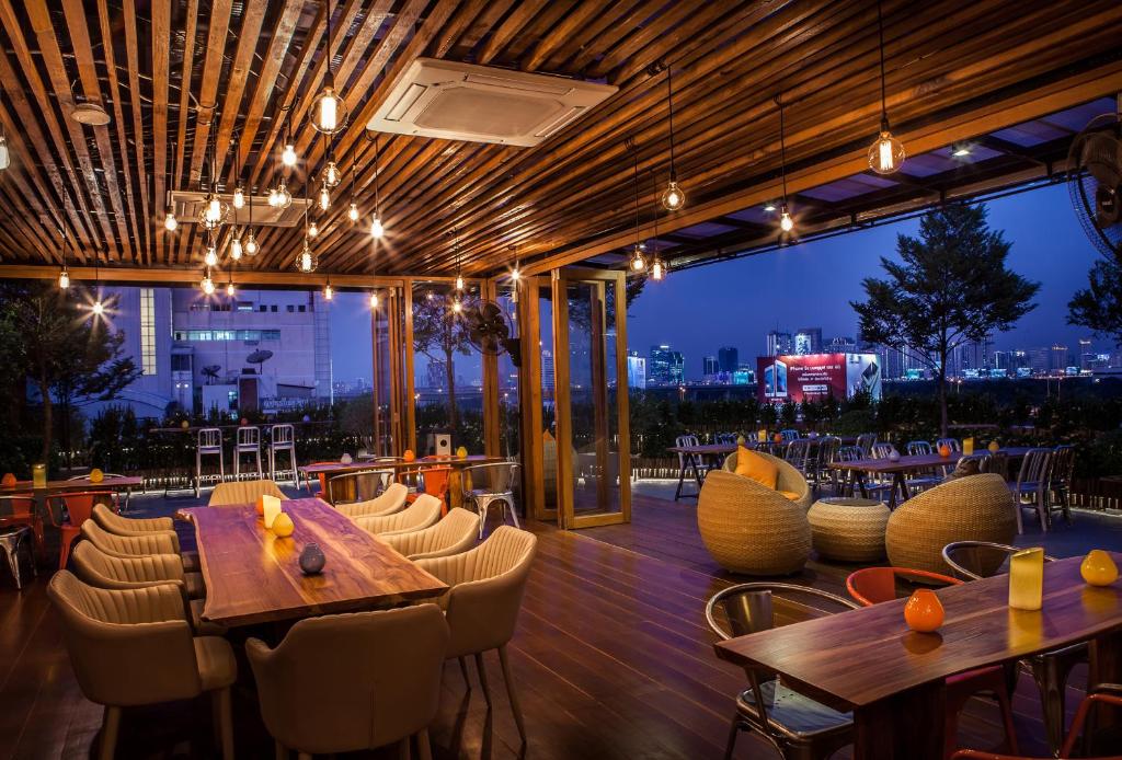 a restaurant with tables and chairs and a view of the city at Metro Pratunam Boutique Hotel in Pratunam