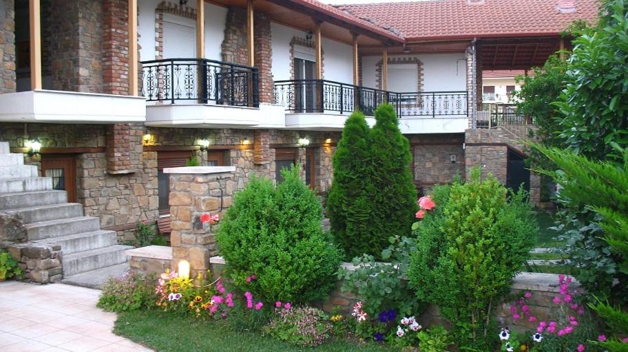 ein Haus mit einem Garten mit Blumen davor in der Unterkunft Spitiko in Kato Loutraki