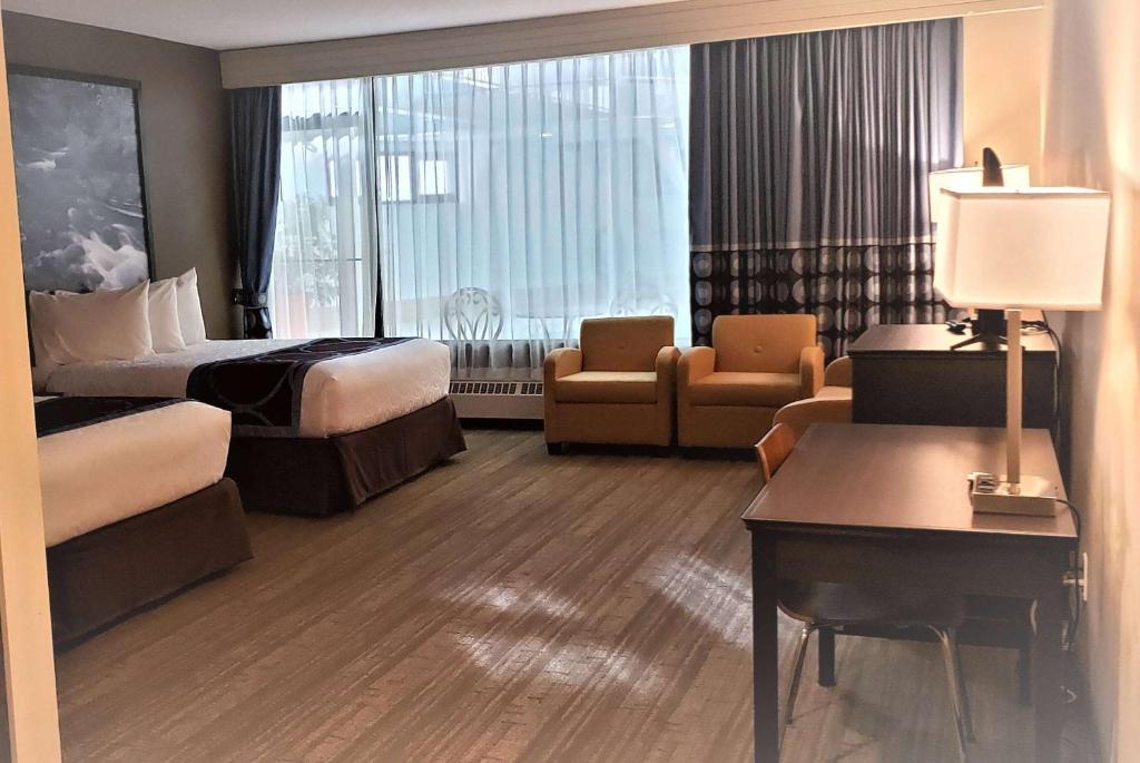a hotel room with two beds and a desk at Super 8 by Wyndham Spruce Grove in Spruce Grove