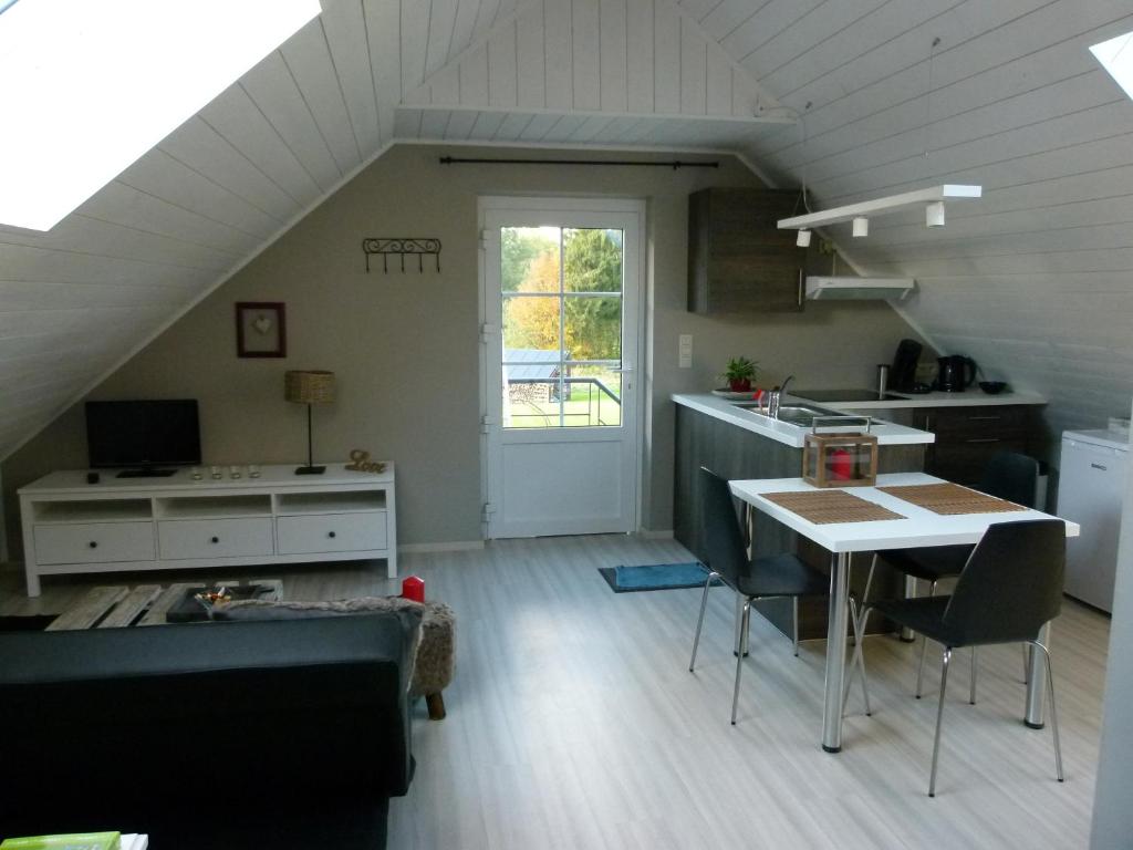a kitchen and living room with a table and a counter at Espace Bien Etre et Spa in Libin