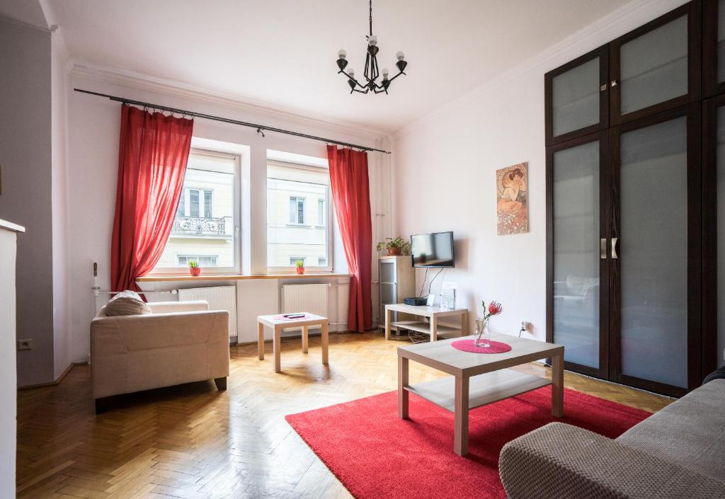 sala de estar con sofá y alfombra roja en Elegant Apartment Ordynacka en Varsovia