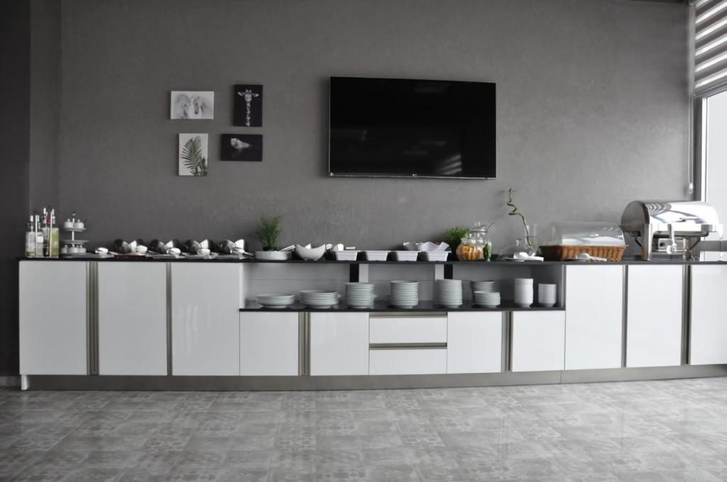 eine Küche mit weißen Schränken und einem TV an der Wand in der Unterkunft Tufad Prestige Boutique in Ankara
