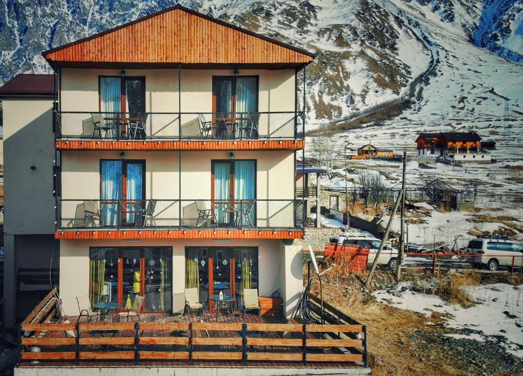 a large building with a balcony on a mountain at Sunshine Kazbegi in Stepantsminda