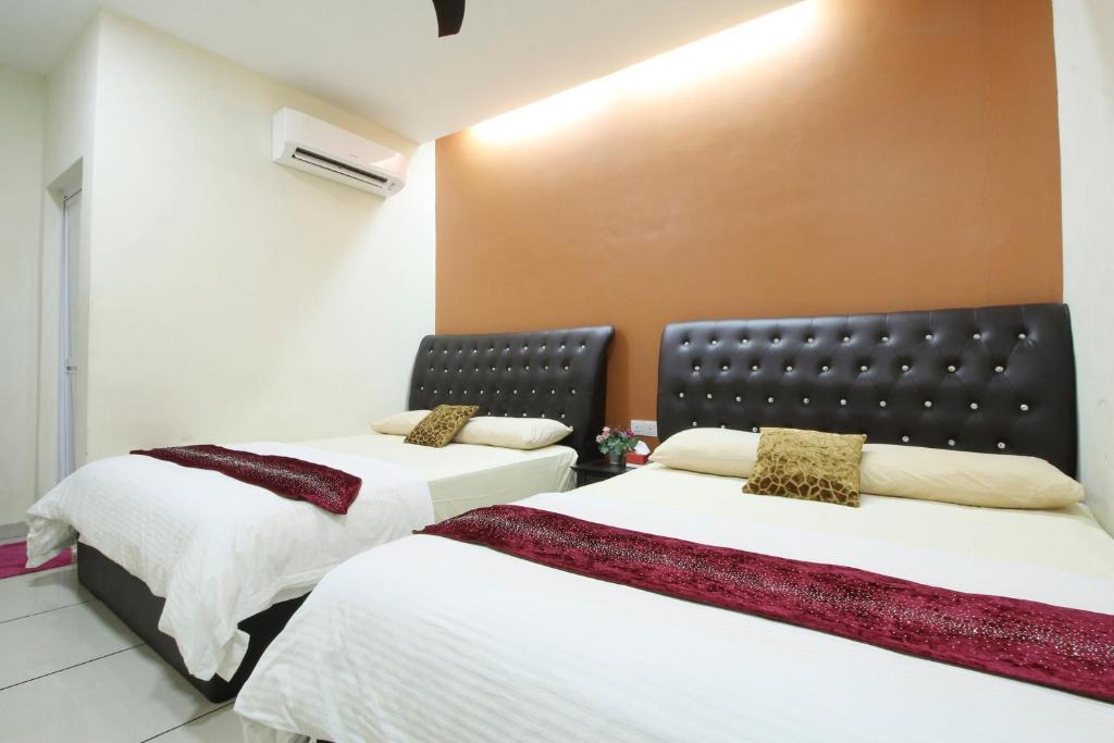 twee bedden naast elkaar in een kamer bij Mimilala Hotel @ i-City, Shah Alam in Shah Alam