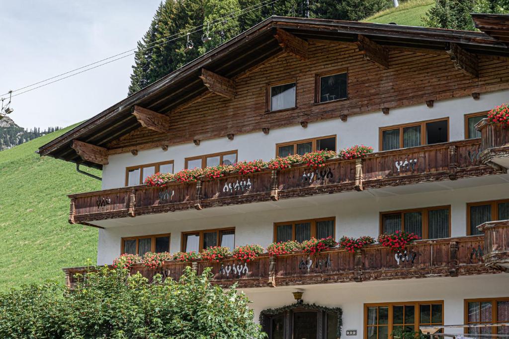 budynek z balkonem pokrytym kwiatami w obiekcie Landhaus Panorama w mieście Berwang