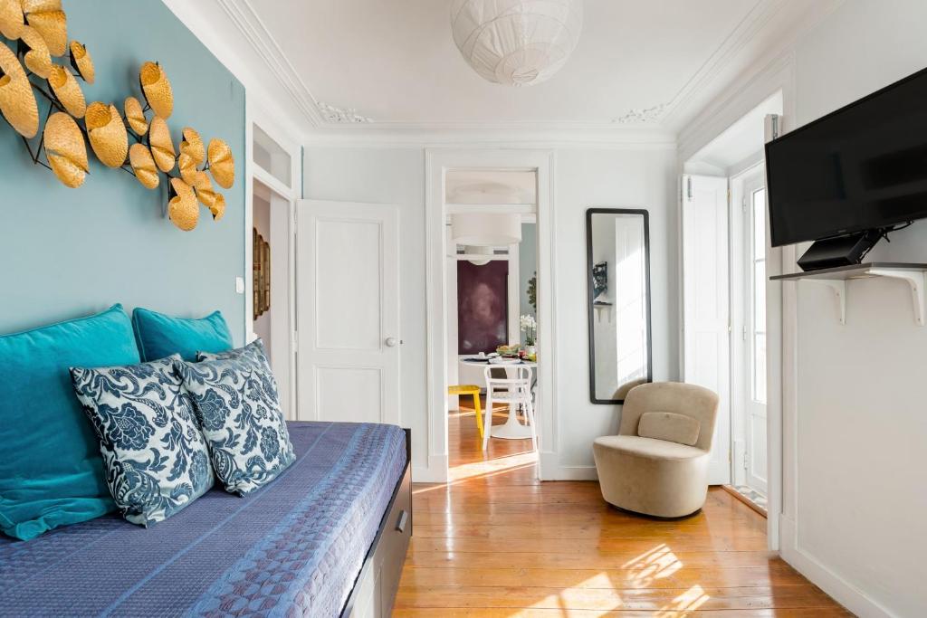 a living room with a blue couch and a chair at Avenida da Liberdade Area, Bright and Newly Renovated 2 Bedroom Apartment, Lisbon Historical Center in Lisbon