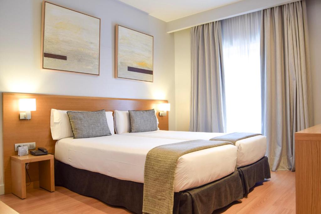 une chambre d'hôtel avec un lit et une fenêtre dans l'établissement Arc La Rambla, à Barcelone