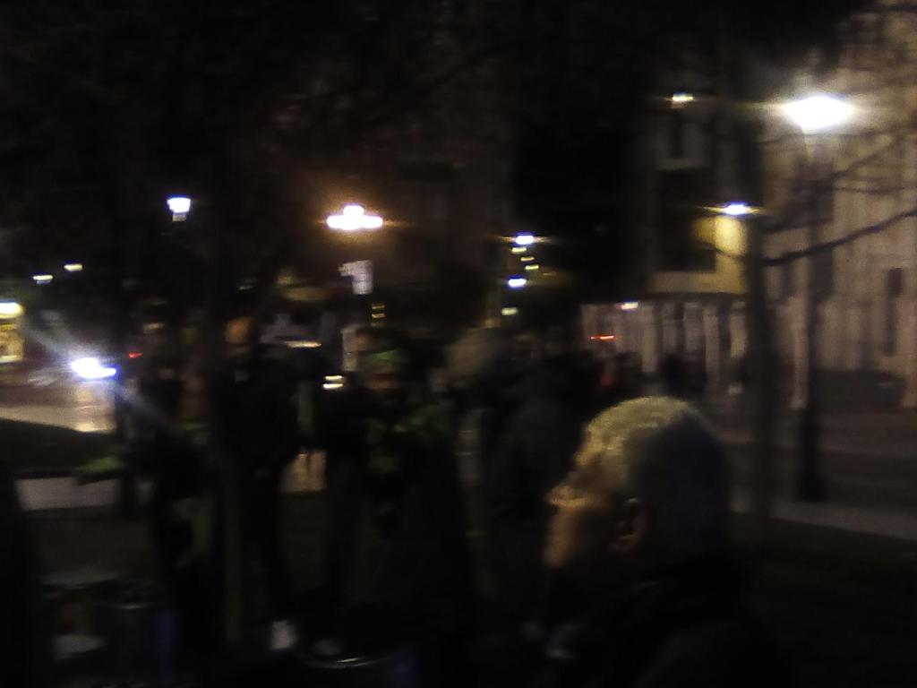 a group of people walking down a street at night at VALLADOLId in Valladolid