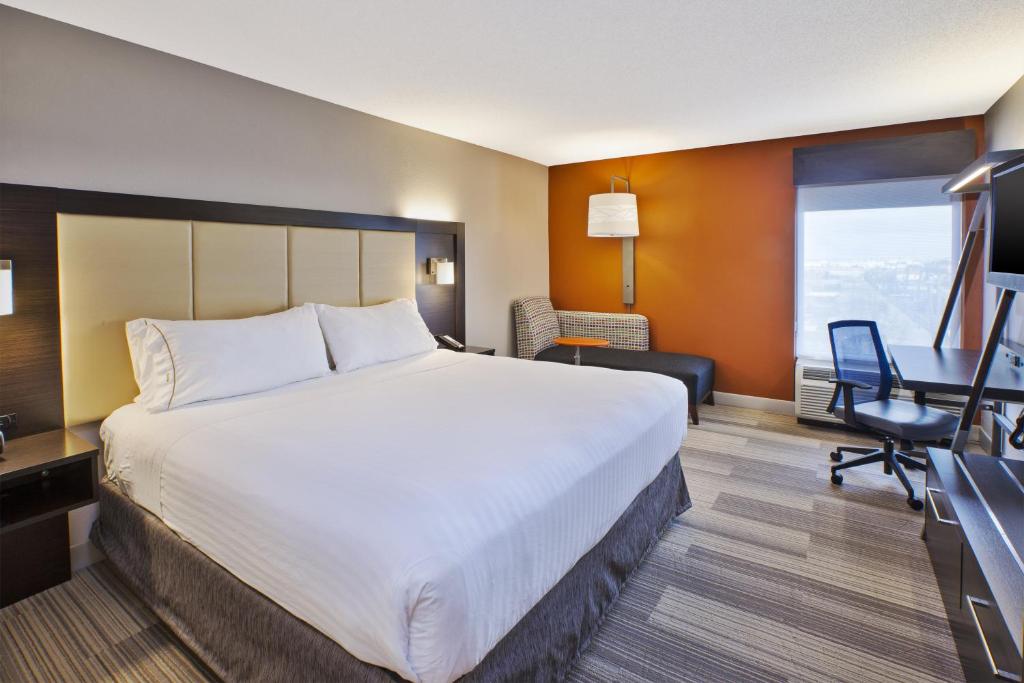 um quarto de hotel com uma cama grande e uma secretária em Holiday Inn Express & Suites Chicago-Midway Airport, an IHG Hotel em Bedford Park