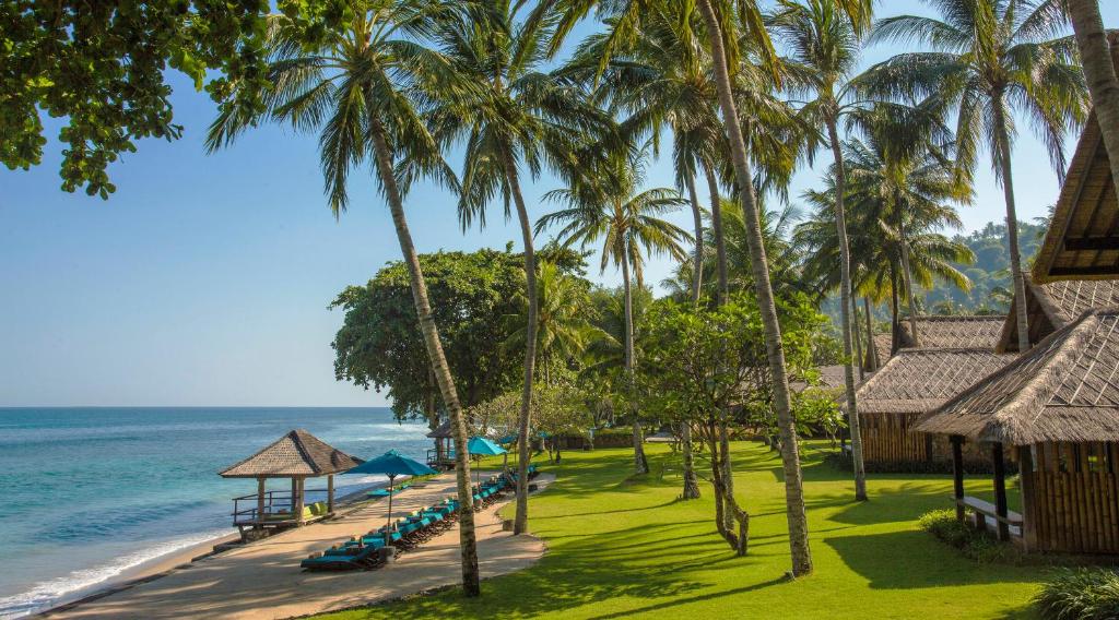 Blick auf einen Strand mit Palmen und das Meer in der Unterkunft Jeeva Klui Resort in Senggigi 