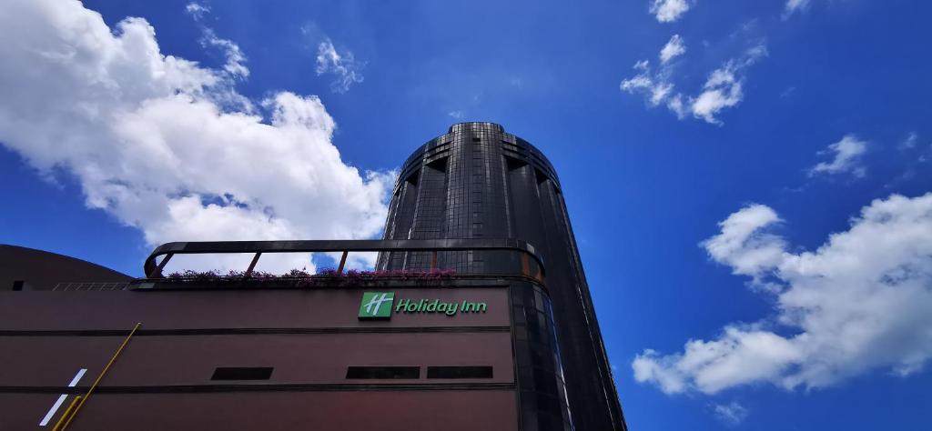 een hoog gebouw met een bord erop bij Holiday Inn Singapore Atrium, an IHG Hotel in Singapore