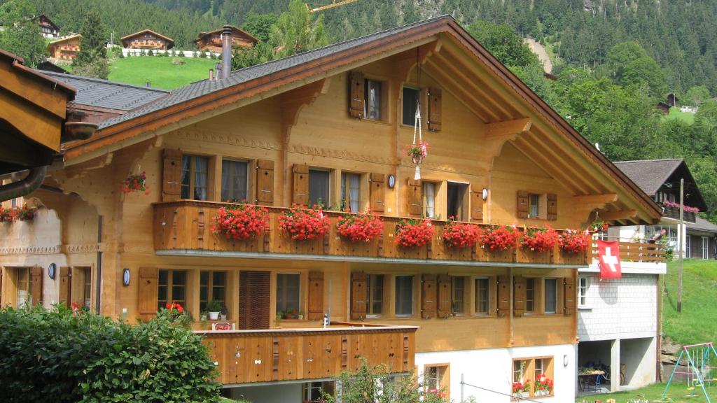 ein großes Holzgebäude mit Blumenkästen auf dem Balkon in der Unterkunft Chalet uf em Stutz 2 in Grindelwald