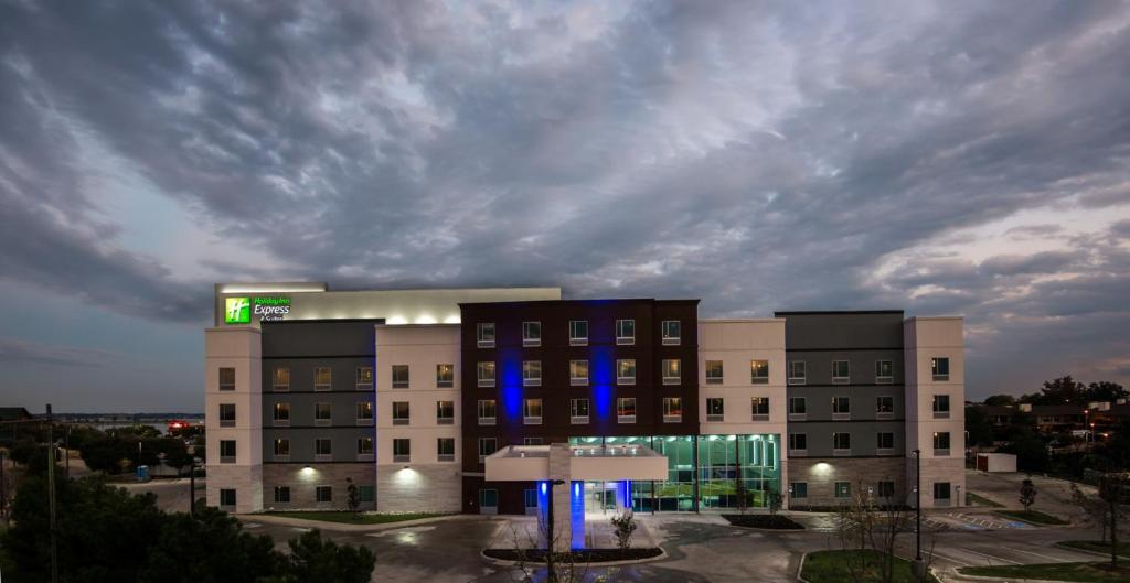 un grand bâtiment avec des lumières bleues devant lui dans l'établissement Holiday Inn Express & Suites Garland E - Lake Hubbard I30, an IHG Hotel, à Garland