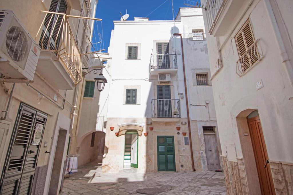 an alley in an old town with white buildings at Palazzo Pezzolla Apartments in Monopoli