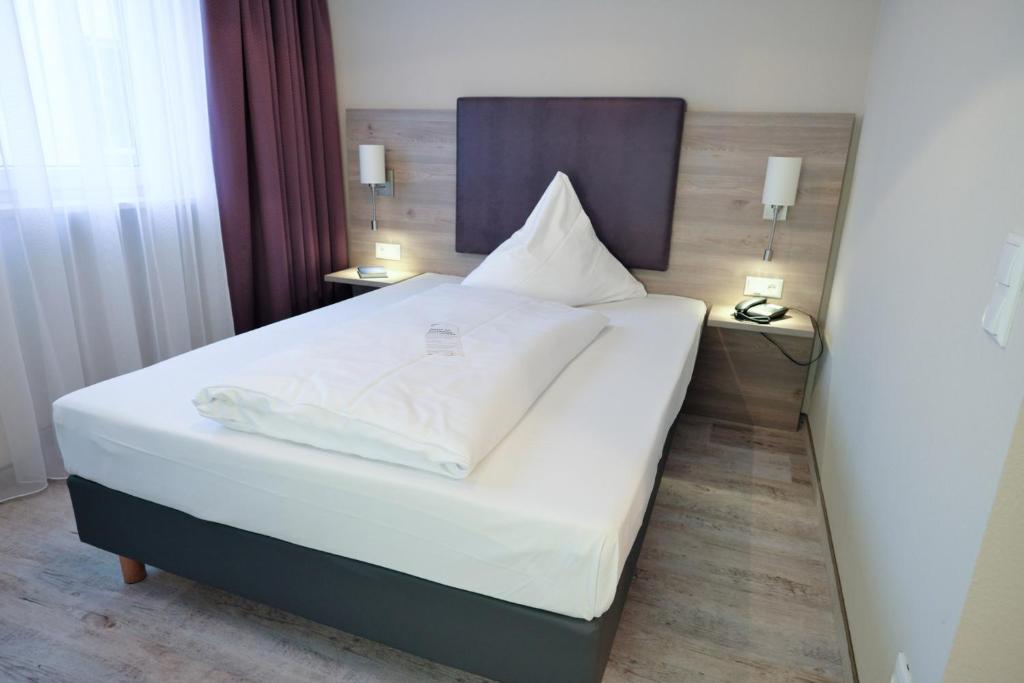 Postel nebo postele na pokoji v ubytování Hotel Römerstadt