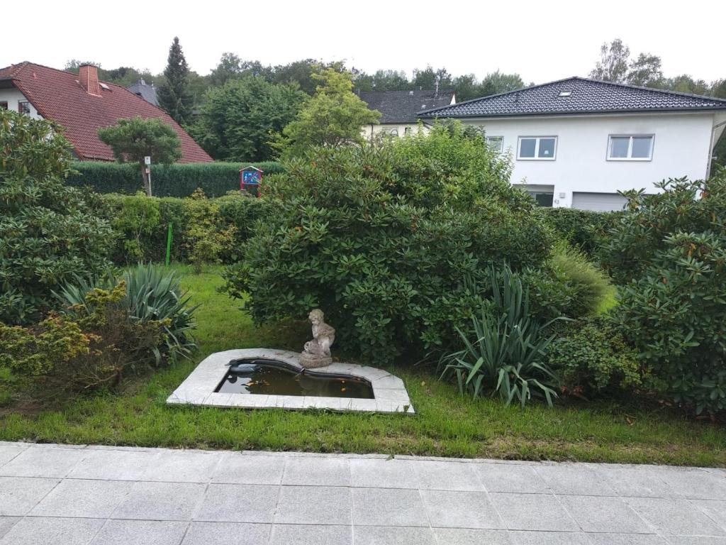 uma estátua no meio de um jardim em Gemütliche Ferienwohnung mit Kamin und Sauna! em Nistertal