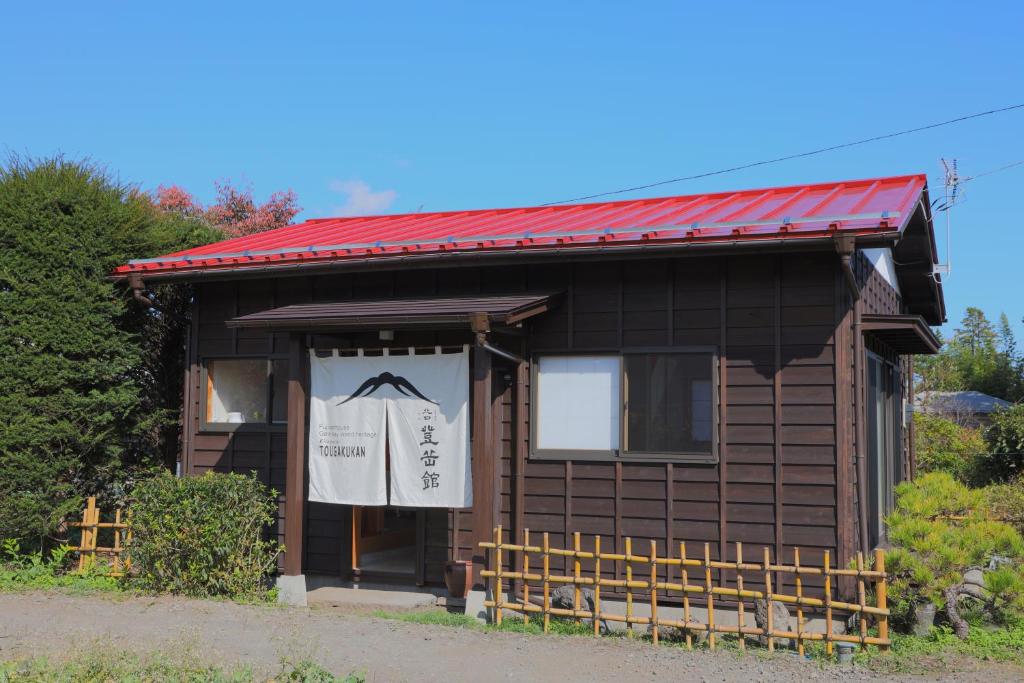 een klein huis met een rood dak en een bord erop bij Kitaguchi Tougakukan in Fujiyoshida