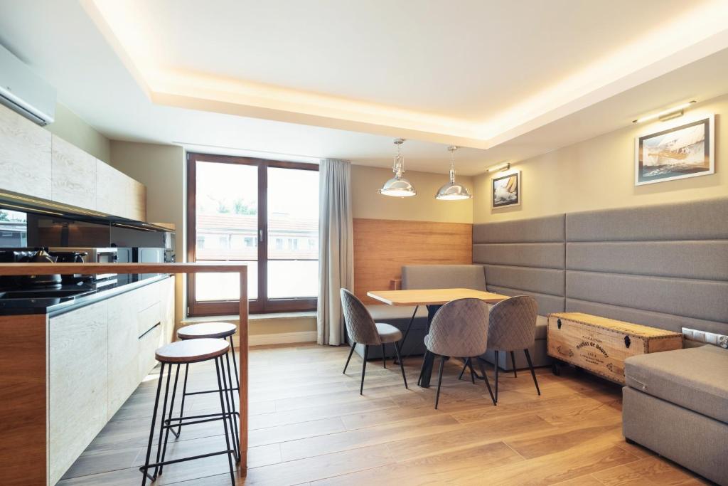 een keuken en eetkamer met een tafel en stoelen bij Grand Apartments - Superior apartment in a luxury closed estate in Sopot