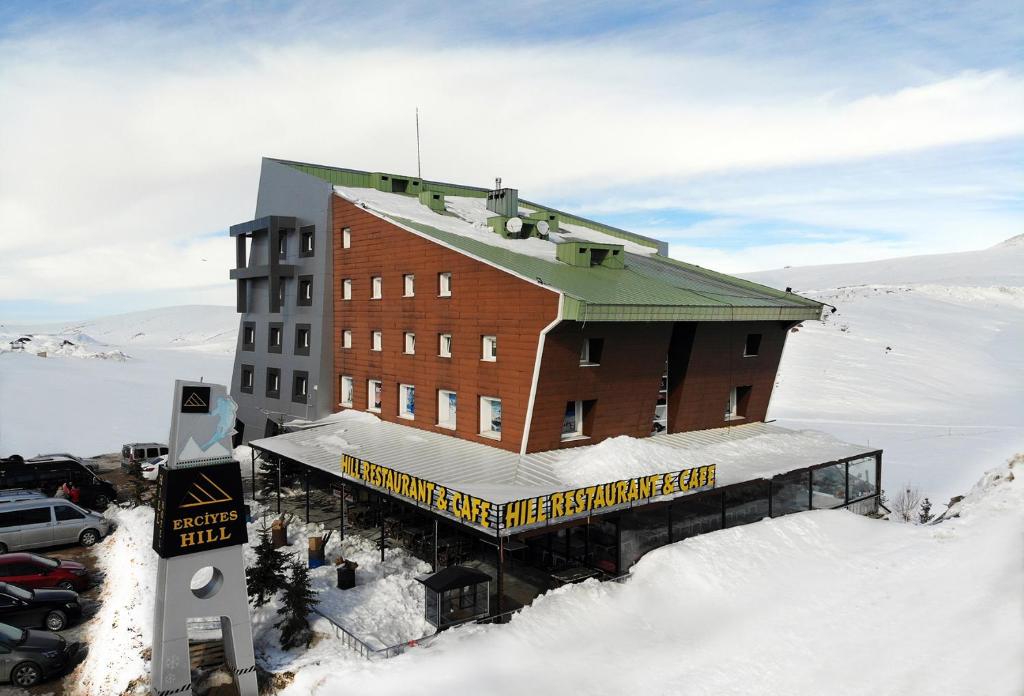 a large building in the snow with a parking lot at ERCİYES HİLL in Erciyes