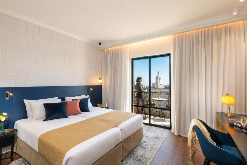 a hotel room with a large bed and a balcony at Prima Kings Hotel in Jerusalem