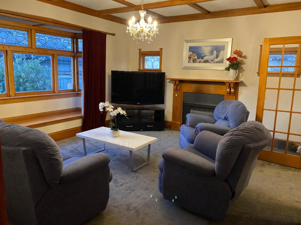 uma sala de estar com duas cadeiras e uma televisão em Knights rd beauty em Lower Hutt
