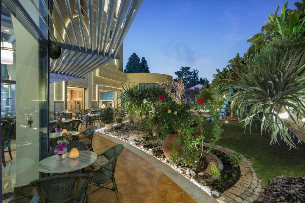 a restaurant with tables and chairs and plants at Merit Lefkosa Hotel & Casino in North Nicosia