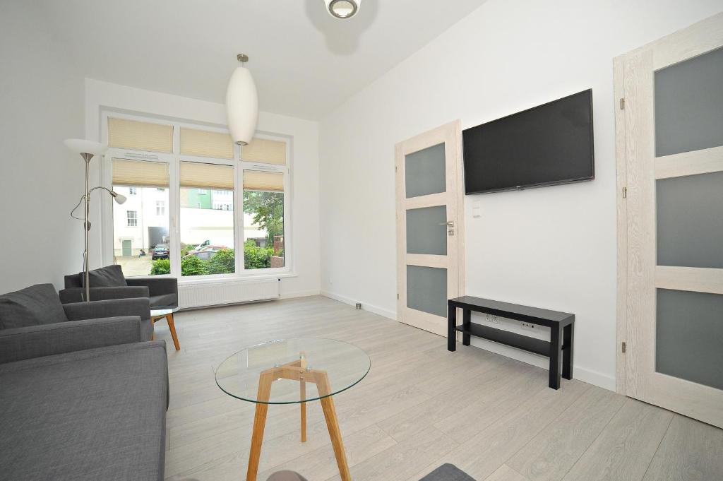 a living room with a couch and a table at Family apartment 50 m from Monte Cassino by Grand Apartments in Sopot