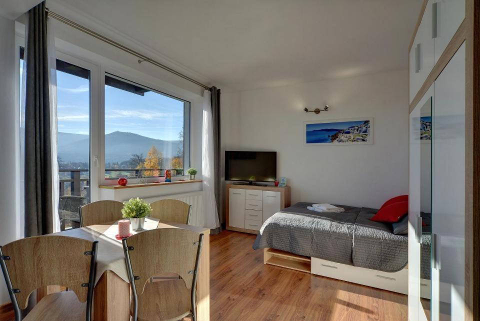 シュクラルスカ・ポレンバにあるApart-Invest Apartament Słoneczny Poranekのベッドルーム1室(ベッド1台、テーブル、窓付)