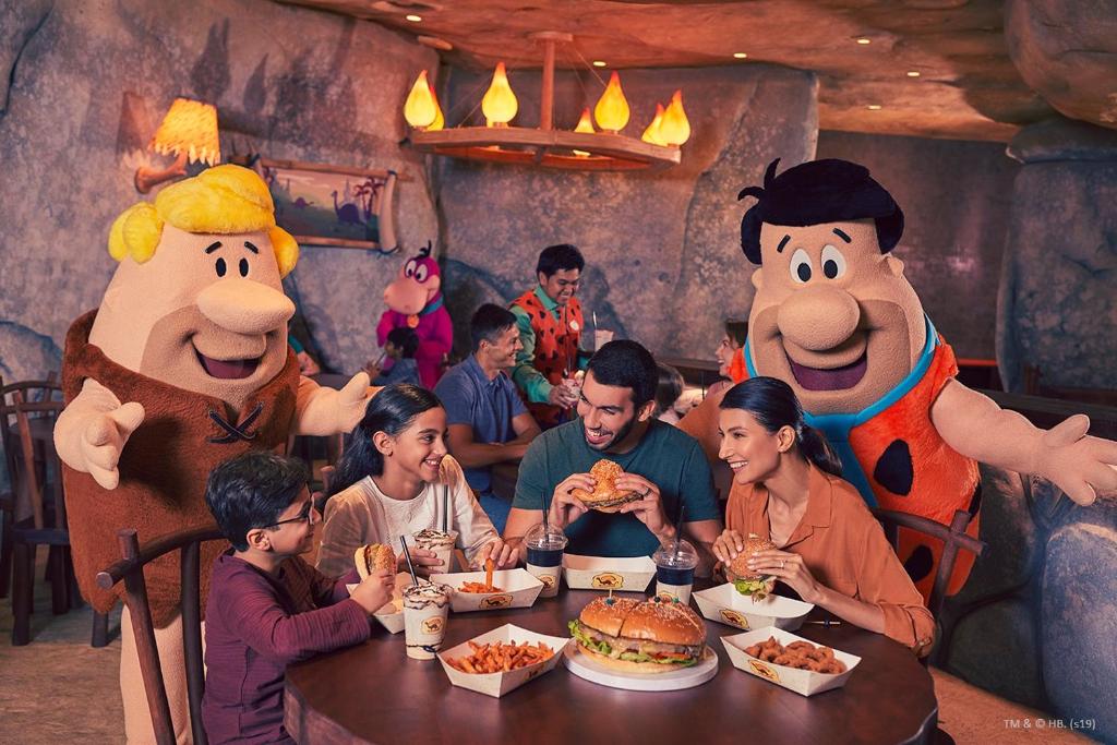 a group of people sitting at a table in a restaurant with stuffed animals at Yas Island Rotana Abu Dhabi in Abu Dhabi