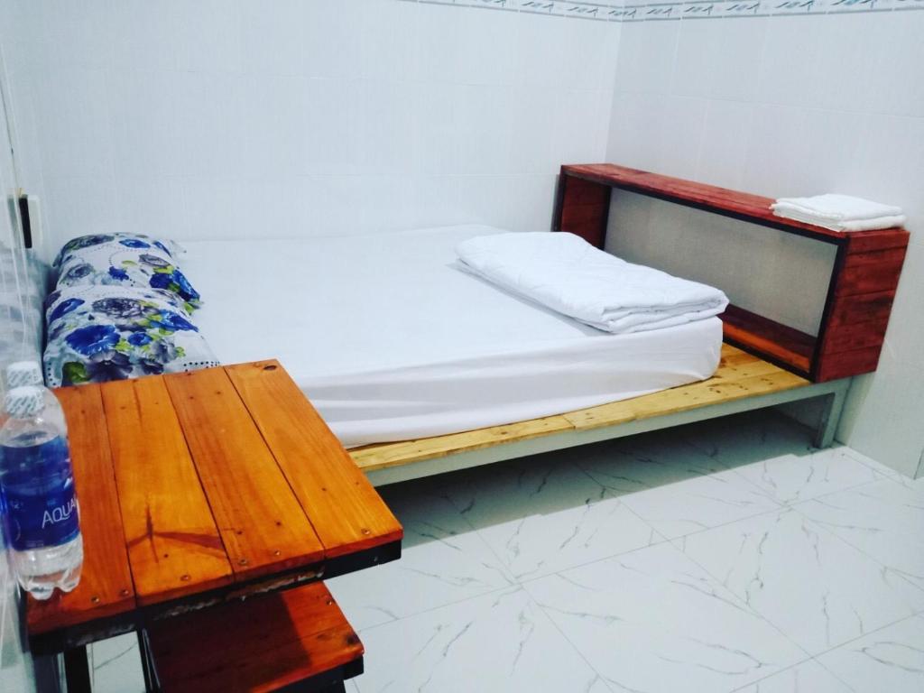 Habitación pequeña con cama y banco de madera. en Nam Du VIEW Guest House, en Nam Du