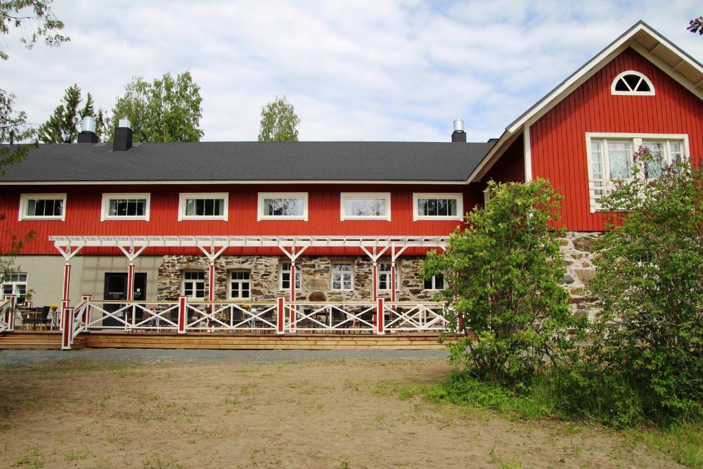 a red barn with a black roof at Hotelli Niittyranta in Niittylahti