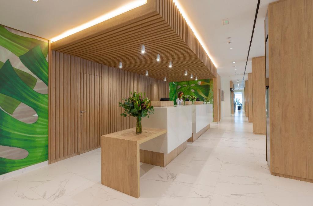 a lobby with a counter with flowers on it at Hotel Helios Costa Tropical in Almuñécar