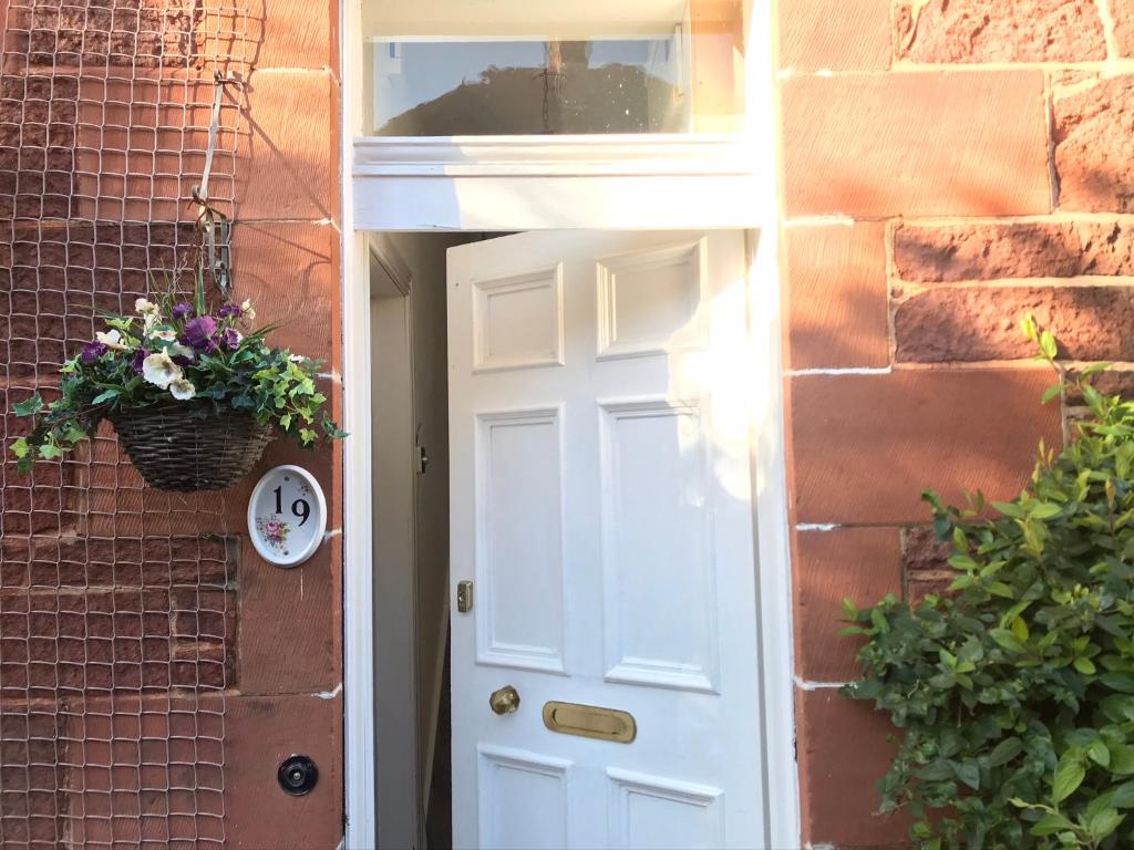 una puerta blanca con una ventana y una cesta de flores en Old Abbey Cottage, en North Berwick