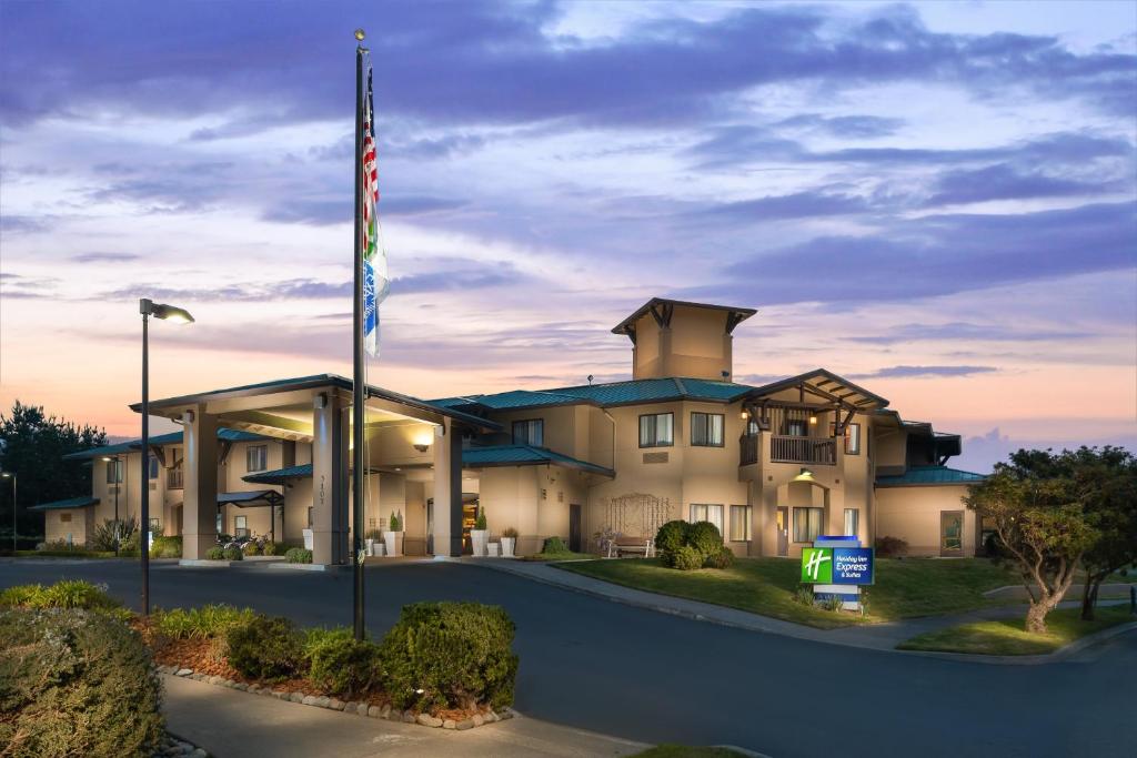 麥金利維爾的住宿－Holiday Inn Express Hotel & Suites Arcata/Eureka-Airport Area, an IHG Hotel，前面有美国国旗的建筑