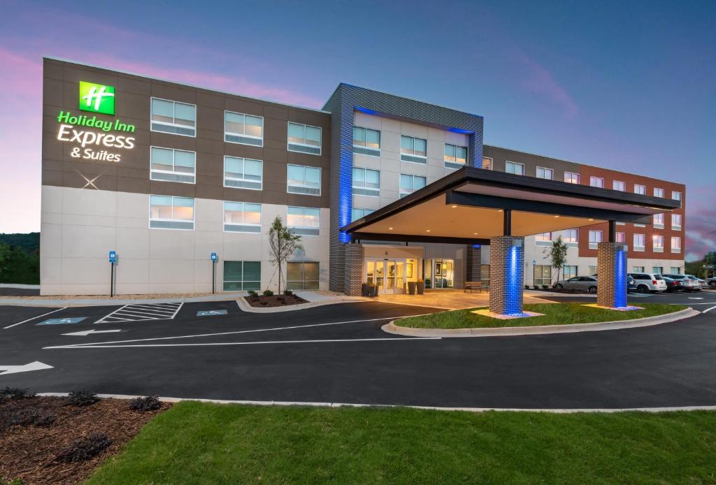 un hotel con un gran edificio con aparcamiento en Holiday Inn Express & Suites Gainesville - Lake Lanier Area, an IHG Hotel, en Gainesville