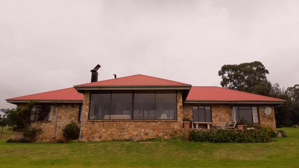 a stone house with a red roof at Berryfields in Dullstroom
