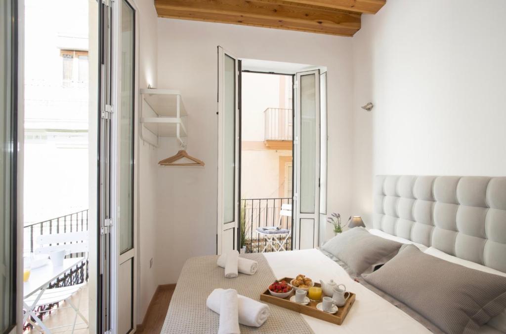 una camera da letto con un letto e un vassoio di frutta; di Mercat Suites a Valencia