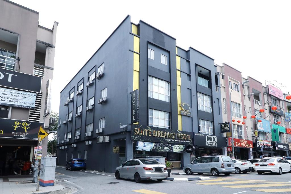 eine Straße mit Autos, die vor einem Gebäude geparkt sind in der Unterkunft Suite Dreamz Hotel in Kuala Lumpur