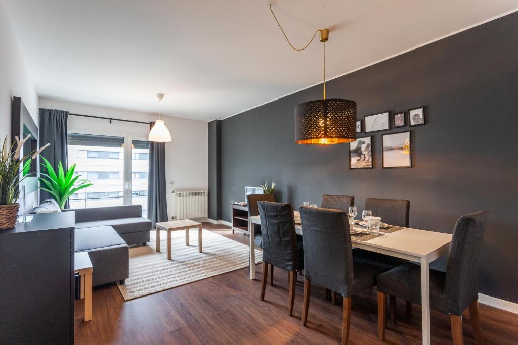 uma sala de jantar e sala de estar com mesa e cadeiras em FLH Expo Modern Flat with Balcony em Lisboa