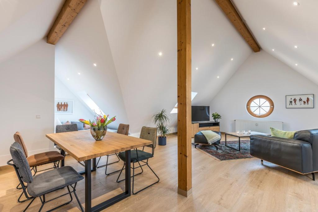 uma sala de estar com uma mesa de madeira e cadeiras em RH-Appartements em Grenzach-Wyhlen