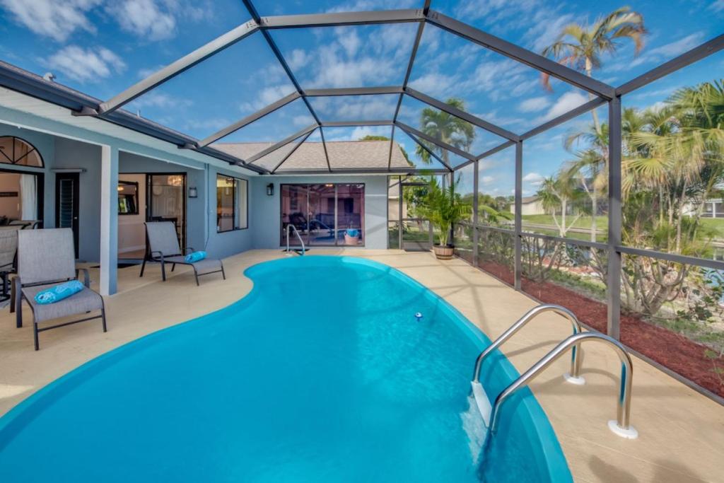 een zwembad in een huis met een glazen dak bij Villa Sunset Cape Coral in Cape Coral