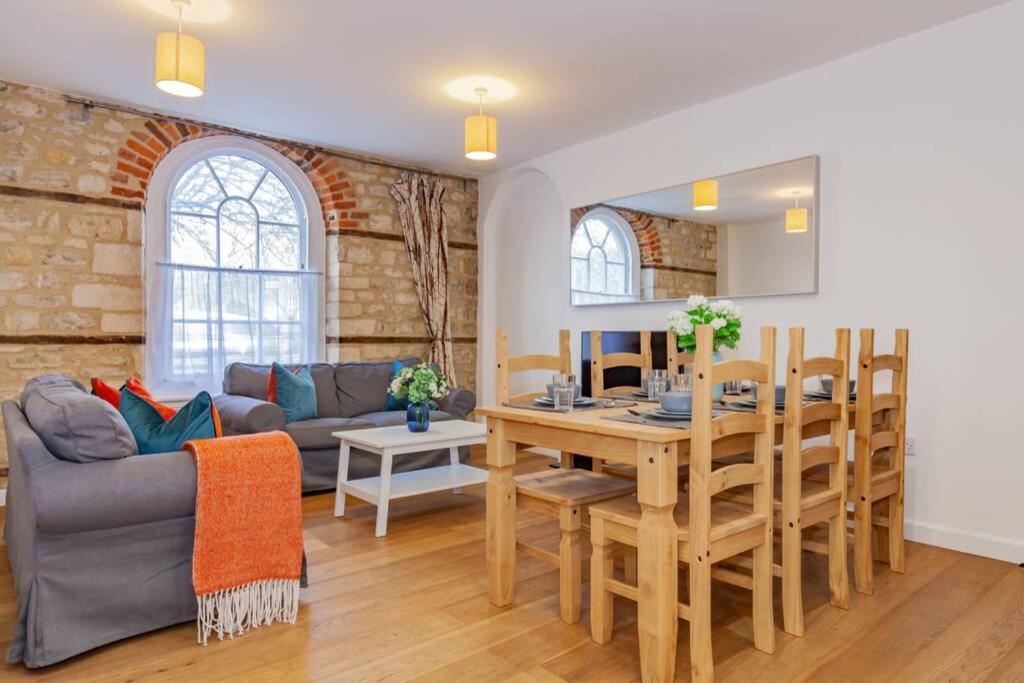 a living room with a table and a dining room at Unique and quirky central apartment with parking in Oxford