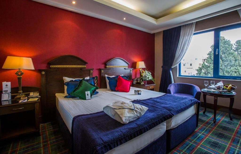 a hotel room with a bed and a red wall at Merit Lefkosa Hotel & Casino in North Nicosia