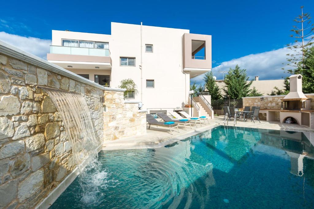 a swimming pool in front of a white house at Peris Villa in Kato Daratso