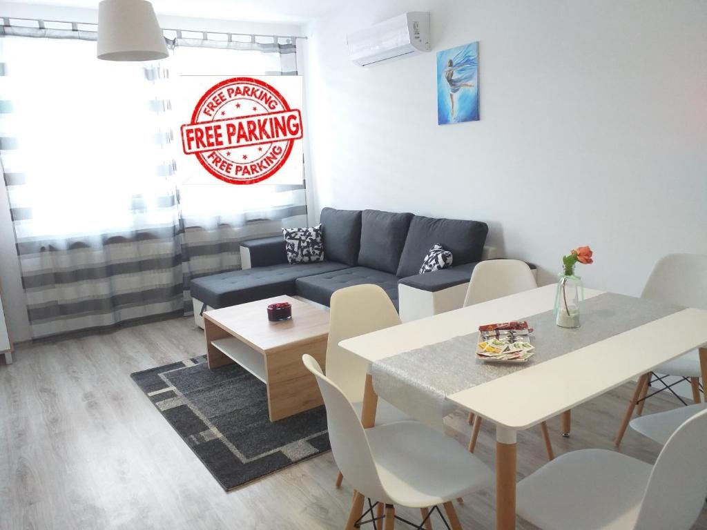 uma sala de estar com um sofá e uma mesa em Hatvan Corner Apartments em Debrecen