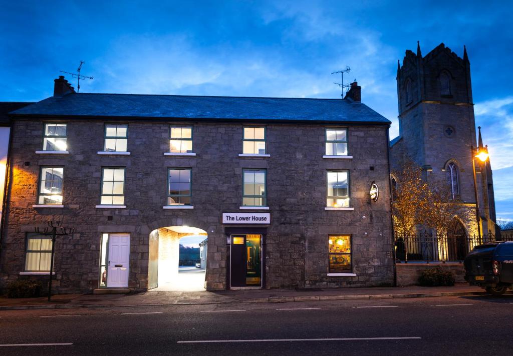 a large brick building with a clock tower at Rooms at the Lower House in Dungannon