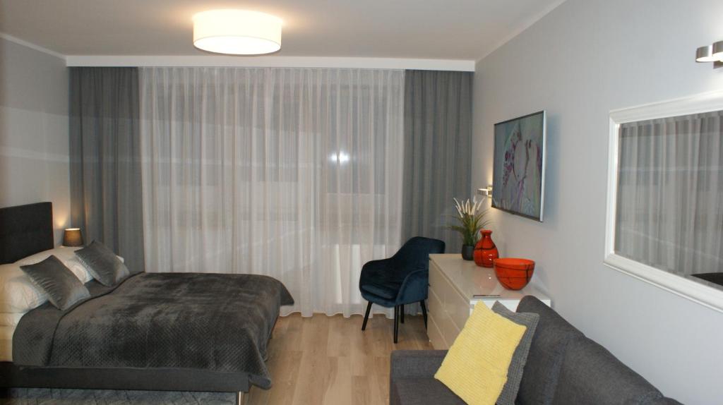 een slaapkamer met een bed en een bank bij Apartament Agata in Świnoujście