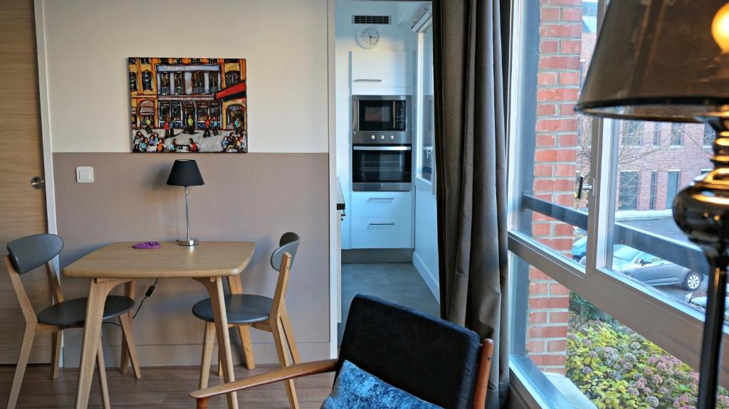 リールにあるLittle Suite - Constanceのテーブルと椅子、窓が備わる小さな客室です。