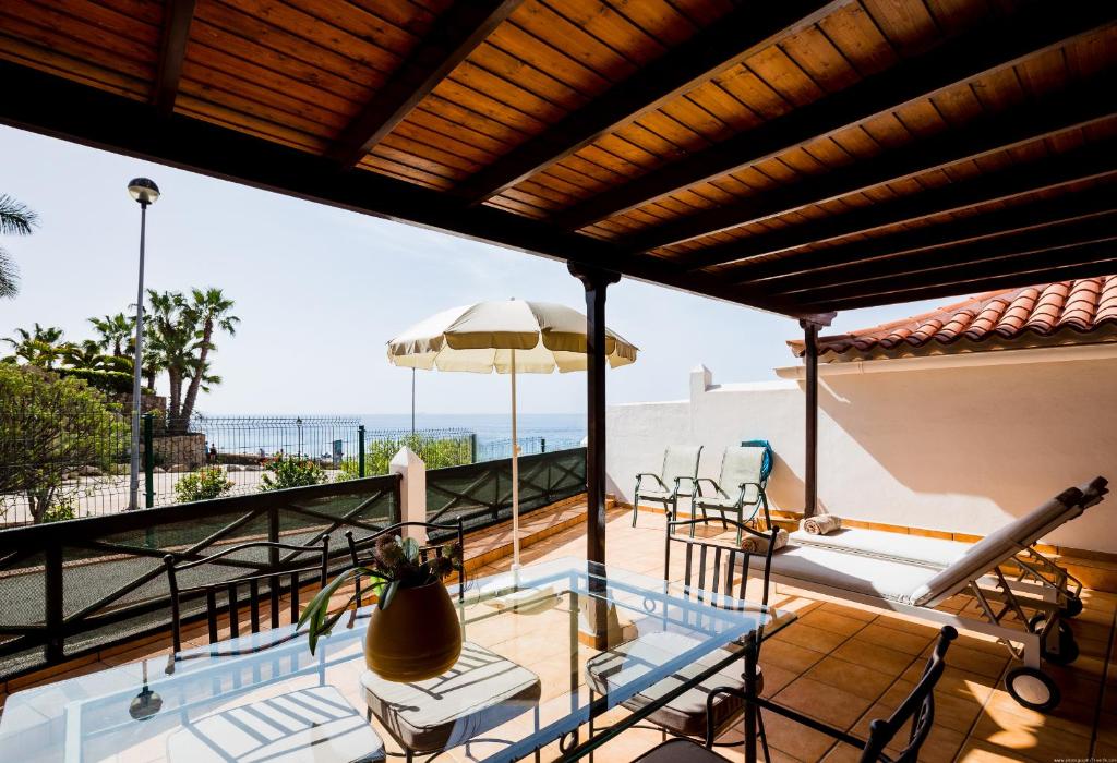 - un balcon avec une piscine, une table et des chaises dans l'établissement El Beril Ocean Front, à Adeje