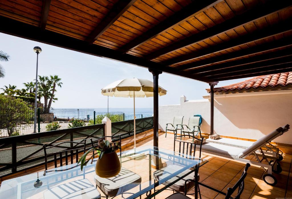 a balcony with a pool and a table and chairs at El Beril Ocean Front in Adeje